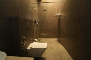 a small bathroom with a toilet and a shower at Vaigayi Ayurveda and Yoga Resort in Kodanad +24 photos