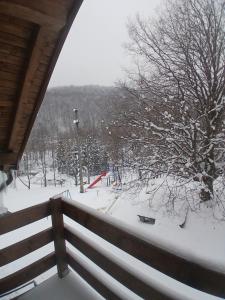 a view of a snow covered park with a fence at Hanul Ibăștean in Brădeţelu
