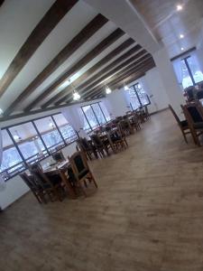 a room with tables and chairs in a building at Hanul Ibăștean in Brădeţelu
