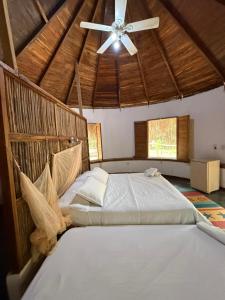 a bedroom with a large bed with a ceiling fan at Las Cabañas del Rio in Minca