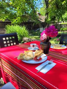 a table with a red table cloth with a plate of food at Къща за гости Българа in Vetren