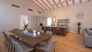 a dining room and kitchen with a table and chairs at Deluxe Villa with heated pool in Brtonigla