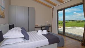 a bedroom with a bed and a large window at Deluxe Villa with heated pool in Brtonigla +53 photos