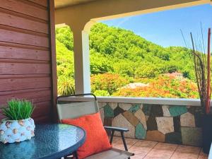 a patio with a table and chairs and a window at Tropical superbe views in Saint Johnʼs