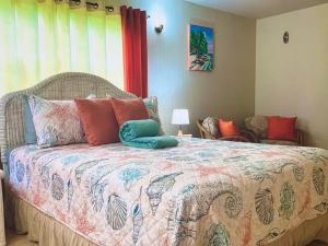 a bedroom with a bed with a colorful comforter at Tropical superbe views in Saint Johnʼs