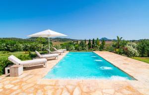 a swimming pool with two chairs and an umbrella at Son Artigues in Manacor