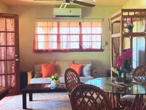 a living room with a couch and a table at Tropical superbe views in Saint Johnʼs +3 photos