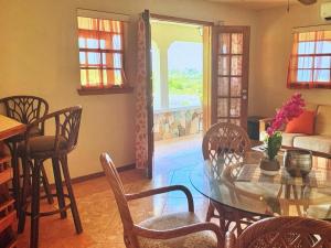 a dining room with a glass table and chairs at Tropical superbe views in Saint Johnʼs
