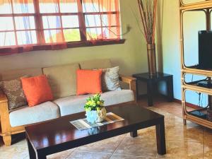 a living room with a couch and a table at Tropical superbe views in Saint Johnʼs