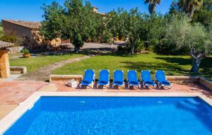 a swimming pool with lounge chairs next to a yard at Can Moleta in Cala Mendia