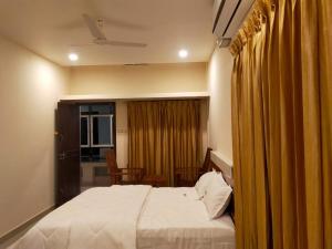 a bedroom with a large bed and a window with curtains at Casal stay in Mannārakkāt