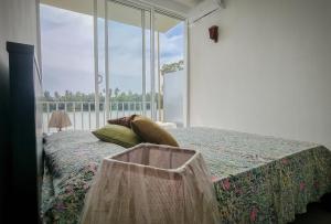 a bedroom with a bed and a large window at blu River villa Ambalangoda in Nikawatawana