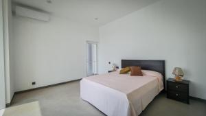 a white bedroom with a bed and a night stand at blu River villa Ambalangoda in Nikawatawana