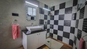 a bathroom with a sink and black and white tiles at blu River villa Ambalangoda in Nikawatawana