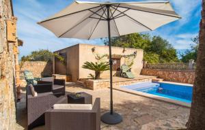 a patio with an umbrella next to a pool at Moli De Ca N'orell in Santanyi
