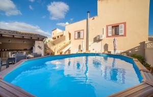 a large blue swimming pool in front of a building at Casa Hermosa in Capdepera