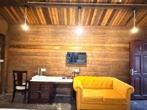 a living room with a yellow couch and a table at Royal cottage by royale palace in Mount Ābu