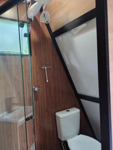 a bathroom with a toilet and a glass door at Cantinho do Chalé in Jaboticatubas +48 photos