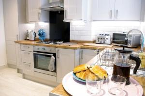 a kitchen with a table with a plate of bread at No 1 Chapel Row in Bakewell