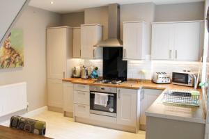 a kitchen with white cabinets and a stove top oven at No 1 Chapel Row in Bakewell