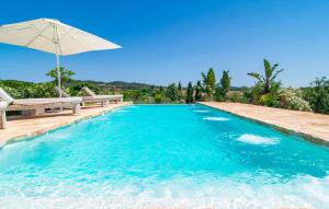 a swimming pool with an umbrella and a bench and an umbrella at Son Artigues in Manacor