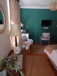 a living room with blue walls and a bed and a lamp at 7th Heaven Guest Unit in Paarl