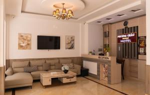 a living room with a couch and a fireplace at Phương Châu Holiday Hotel Đà Lạt in Da Lat