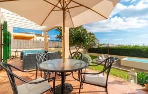a patio with a table and chairs and an umbrella at Sa Copinya in Cala Bona