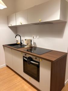 a kitchen with a sink and a counter top at Charmant T2 hyper-centre, proche gare & mer in Saint-Brieuc +7 photos