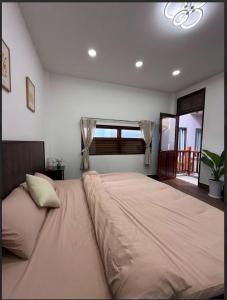 a large bed in a bedroom with a window at Ovana Homestay in Phan Thiet