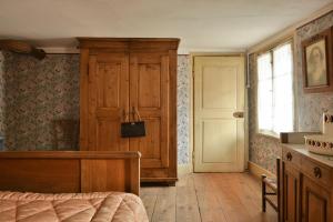 a bedroom with a bed and a window and a door at Chez Oma, La petite ferme in Weinbourg