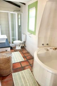 a bathroom with a tub and a toilet and a sink at Verdoesie Jacobsbaai in Jacobs Bay +27 photos