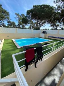 a swimming pool with a table and chairs next to it at Cozy House in Charneca +23 photos