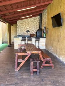 a group of picnic tables in a room with a kitchen at Chalé Ubajara in Ubajara