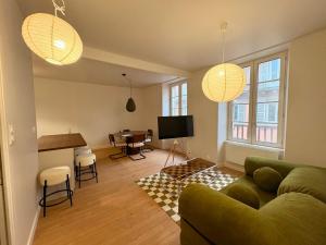 a living room with a couch and a table at Charmant T2 hyper-centre, proche gare & mer in Saint-Brieuc