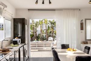 a kitchen with a table with a bowl of fruit at Protaras Villa Alina in Protaras