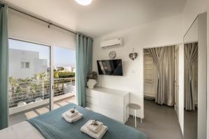 a bedroom with a bed with two towels on it at Protaras Villa Alina in Protaras
