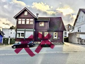 a red car parked in front of a house at Ferienwohnung HarzReise in Braunlage