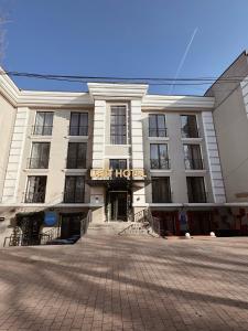 a large white building with a sign that reads hotel at Unit Hotel in Almaty