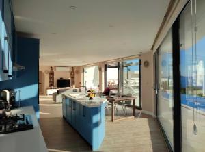 a kitchen with blue cabinets and a table in a room at Villa Ship Ahoy in Kaş