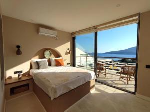 a bedroom with a bed and a balcony with a view at Villa Ship Ahoy in Kaş