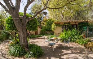 a patio with a table and chairs under a tree at Can Pintad in Ruberts