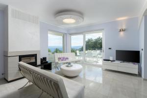 a living room with a fireplace and a tv at Villa Luce in Labin