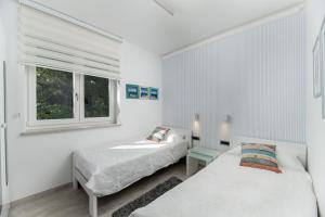 two beds in a white room with a window at Villa Luce in Labin +52 photos