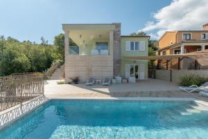 a house with a swimming pool in front of a house at Villa Luce in Labin