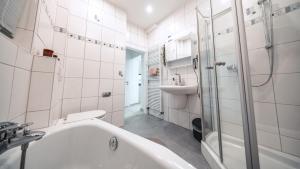 a white bathroom with a tub and a sink at FlexHome Stadtnatur Ferienwohnung in Lippstadt +18 photos