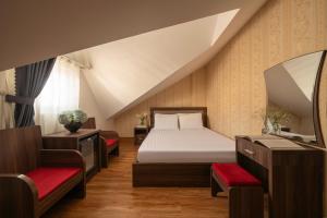 a bedroom with a bed and two chairs and a mirror at Phương Châu Holiday Hotel Đà Lạt in Da Lat