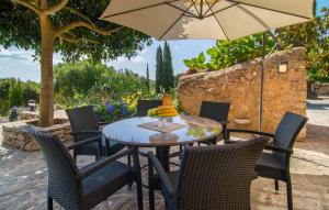 an outdoor table with chairs and an umbrella at S'alzinar Gran in Artá