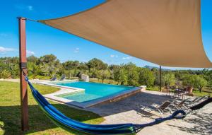 a hammock and chairs next to a swimming pool at S'oratge in Artá