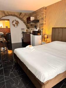 a bedroom with a large bed and a kitchen at Jacuzzi des Voutes in Vesoul